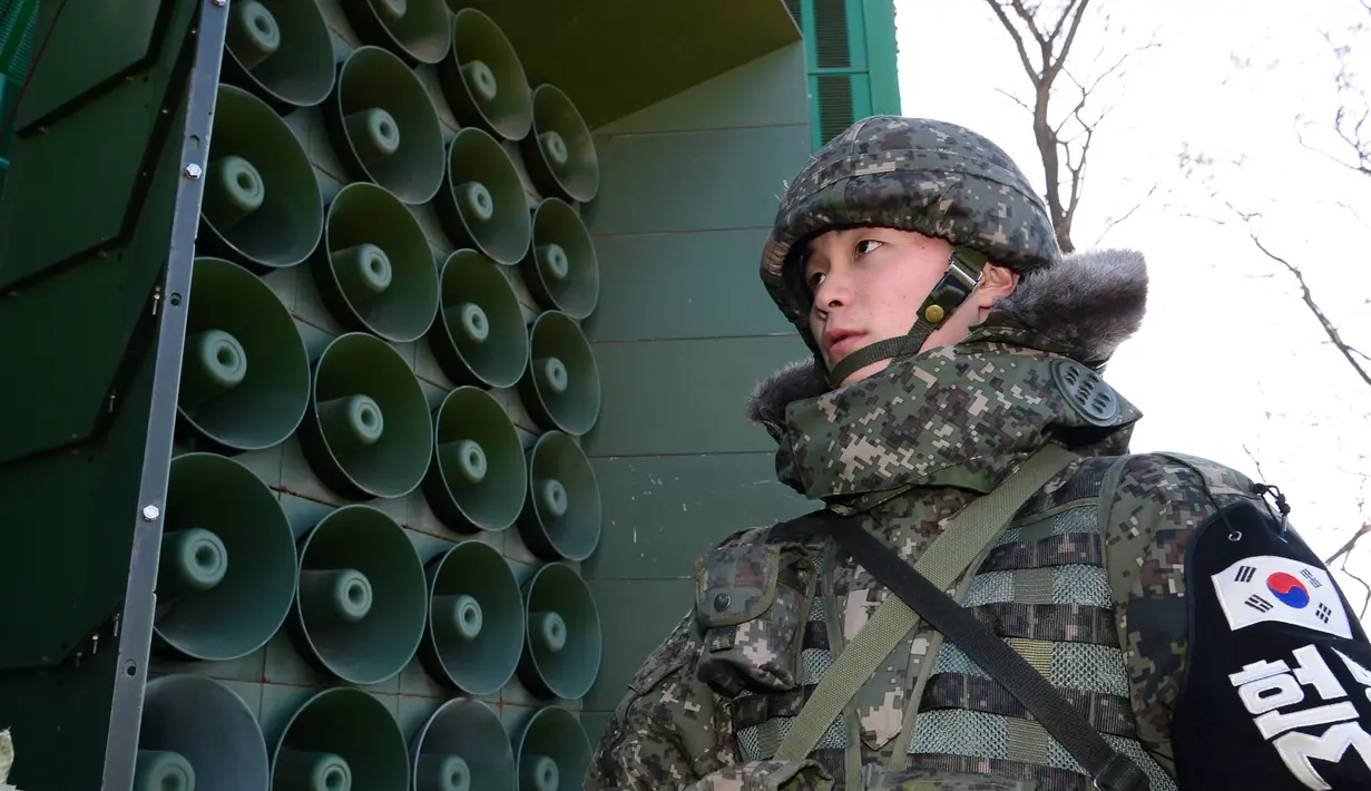 Tentara Korsel berdiri di dekat pengeras suara yang dipasang di sebelah selatan zona demiliterisasi, Yeoncheon, Jumat (8/1/2016). Pengeras suara tersebut memasang musik pop Korea, berita dan kritik atas Korea Utara ke arah perbatasan. (YONHAP/AFP)