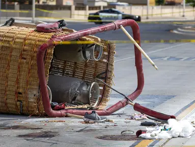 Keranjang balon udara yang jatuh tergeletak di trotoar di Albuquerque, New Mexico, Amerika Serikat, Sabtu (26/6/2021). Polisi mengatakan lima penumpang tewas setelah jatuh di jalan yang ramai. (AP Photo/Andres Leighton)