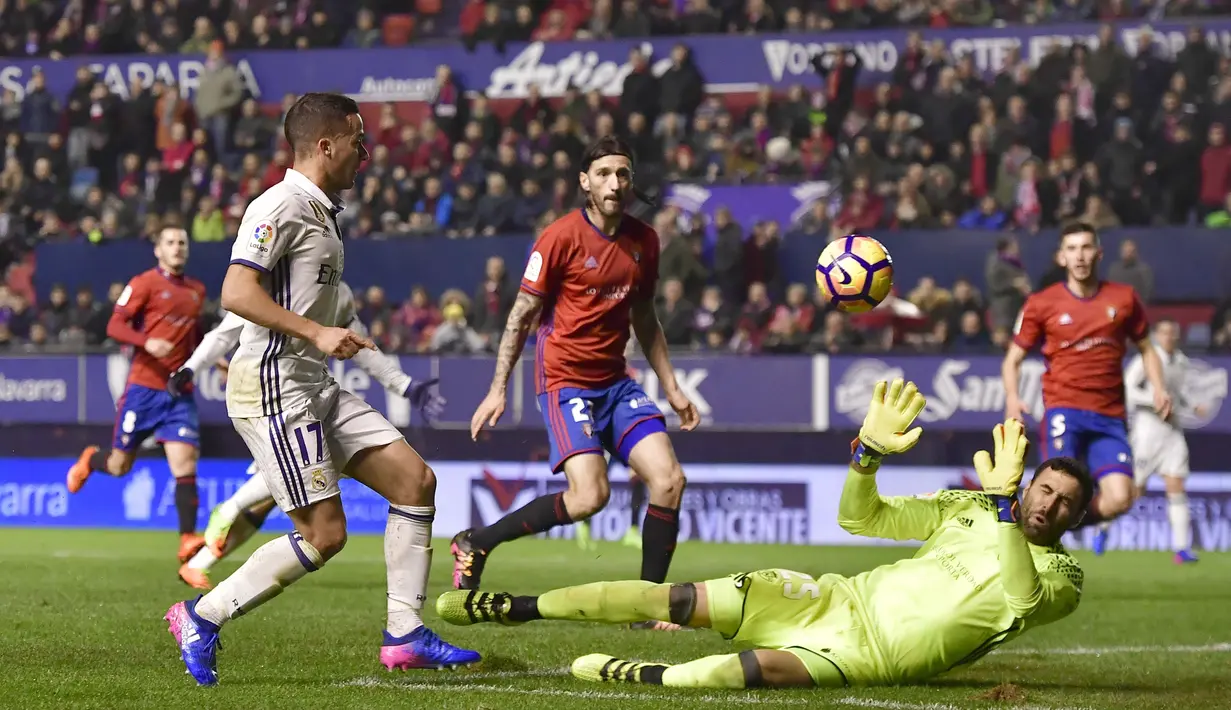 Pemain Real Madrid, Lucas Vazquez (kiri) mencetak gol ke gawang Osasuna dengan mengecoh kiper, Salvatore Sirigu pada lanjutan La Liga di El Sadar stadium, Pamplona, (11/2/2017).  Real Madrdi menang 3-1. (AP/Alvaro Barrientos)