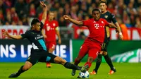 Gelandang Muenchen, Douglas Costa (kanan) berusaha melewati gelandang Arsenal, Francis Coquelin pada lanjutan Grup F liga champions di stadion Allianz Arena, Munich, Jerman (4/11). Muenchen menang atas Arsenal dengan skor 5-1. (Reuters/Michael Dalder) 