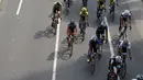 Para pebalap saat melewati ruas jalan protokol Sudirman pada ajang Tour de Jakarta di Bundaran Hotel Indonesia, Jakarta, Sabtu (30/7/2016). (Bola.com/Nicklas Hanoatubun)