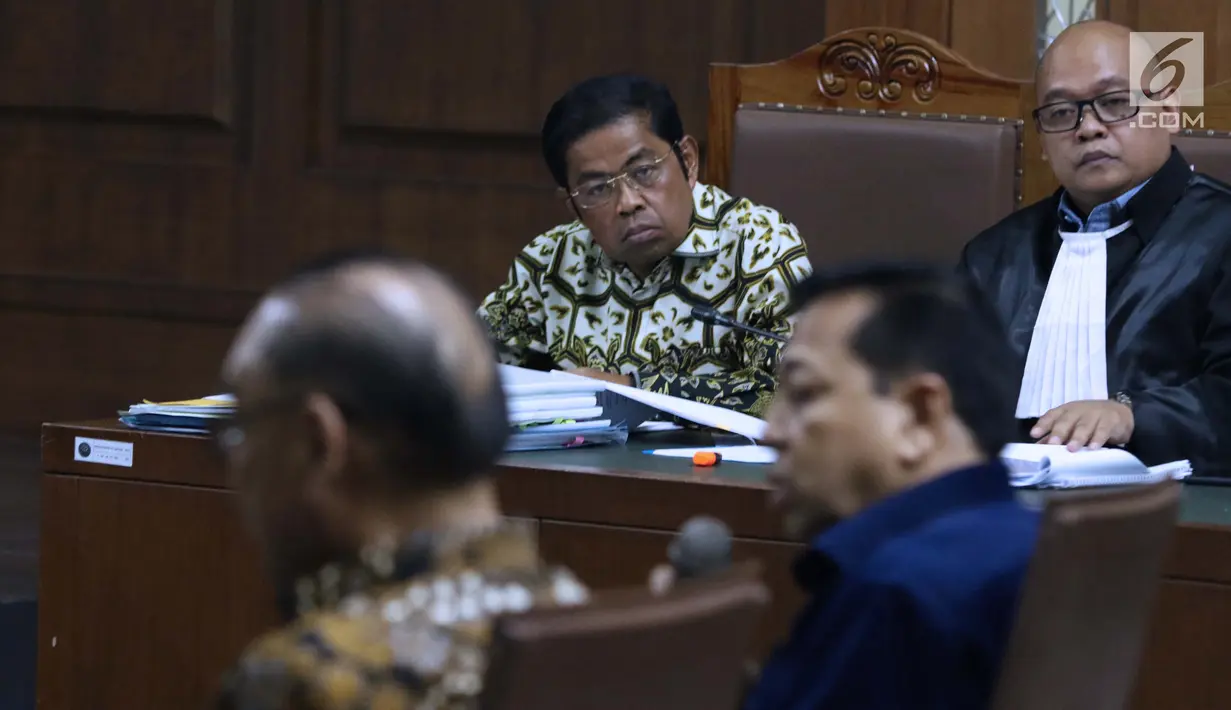 Terdakwa dugaan suap pembangunan PLTU Riau-1, Idrus Marham menyimak keterangan Mantan Ketua DPR, Setya Novanto di sidang lanjutan dugaan suap pembangunan PLTU Riau-1 di Pengadilan Tipikor, Jakarta, Selasa (19/2). (Liputan6.com/Helmi Fithriansyah)