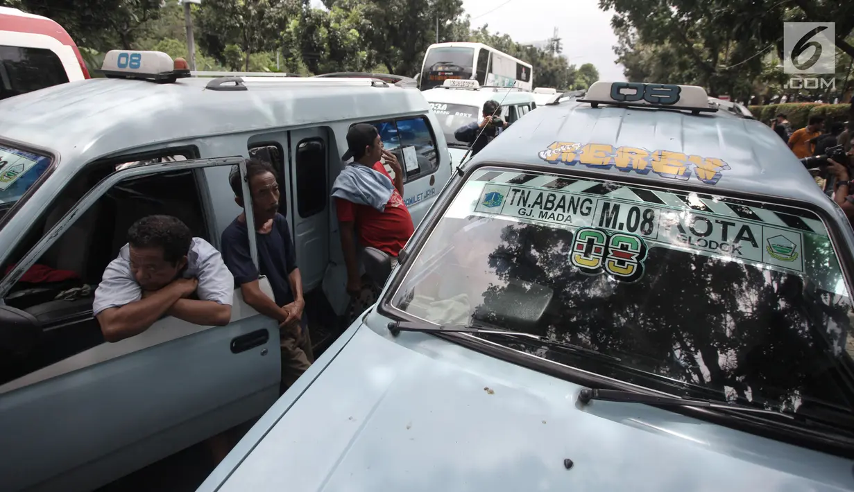 Sejumlah sopir angkot Tanah Abang berkumpul di dekat mobilnya saat melakukan aksi di depan Balai Kota DKI Jakarta, Rabu (31/1). Mereka juga menuntut agar Pemprov DKI Jakarta segera membuka kembali jalan tersebut. (Liputan6.com/Arya Manggala)