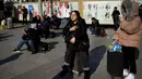 Calon pemudik menunggu jadwal keberangkatan kereta mereka di luar pintu masuk stasiun Beijing, Jumat (10/1/2020). Puluhan ribu warga China telah meninggalkan kota-kota besar China menuju kampung halaman, guna merayakan Tahun Baru Imlek yang akan jatuh pada 25 Januari mendatang. (WANG ZHAO/AFP)