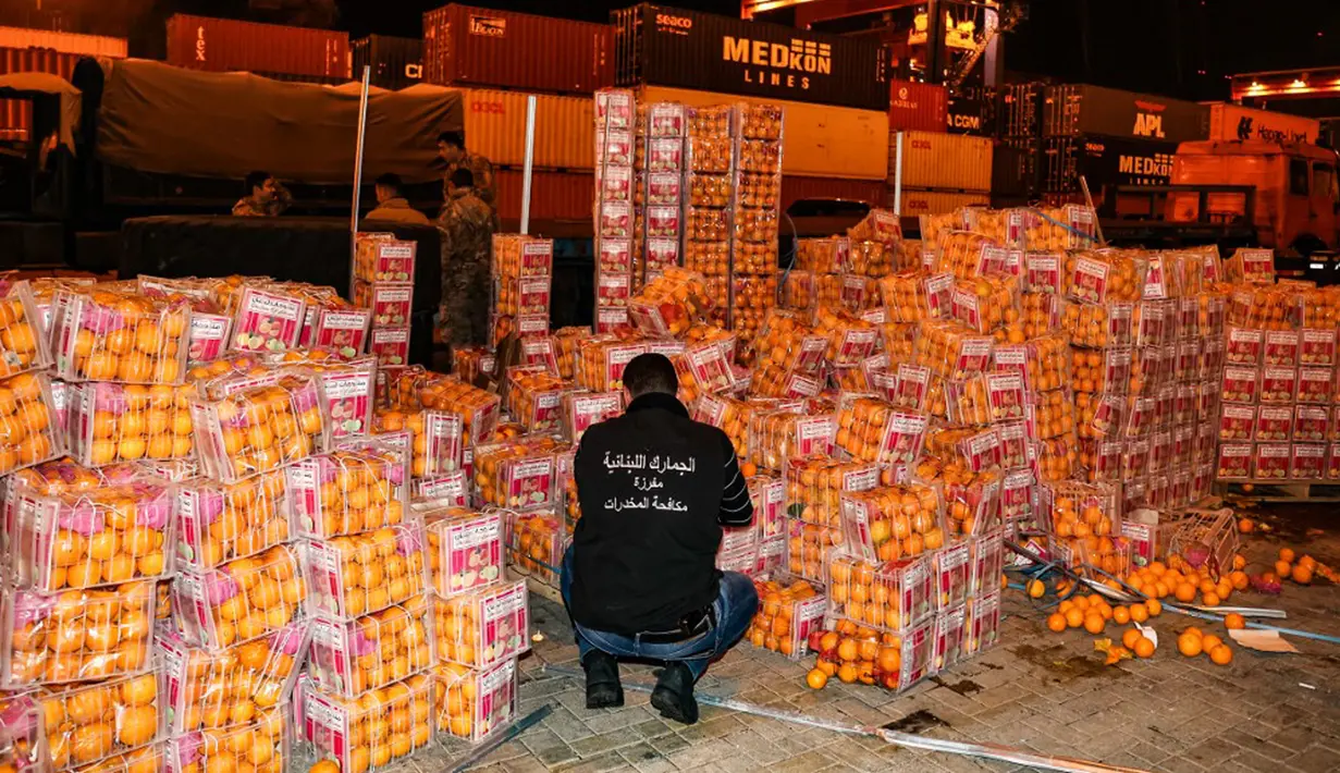 Petugas bea cukai memeriksa kotak jeruk palsu berisi pil Captagon di Pelabuhan Beirut, Lebanon, 29 Desember 2021. Bea Cukai Lebanon menyita sembilan juta pil Captagon dalam jeruk palsu yang ditujukan ke salah satu negara Teluk. (ANWAR AMRO/AFP)