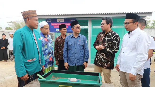 Group Head XL Axiata East Region Dodik Ariyanto (kemeja biru) merilis program budi daya maggot berbasis teknologi IoT untuk santri di Ponpes Miftahul Ulum Sekar Anyar, Pamekasan. (Liputan6.com/ Agustin Setyo Wardani)
