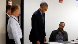 Presiden AS Barack Obama tersenyum ketika berbincang dengan pekerja jajak pendapat di TPS awal di Chicago, Illinois, Jumat (7/10). Obama memberikan suaranya lebih dahulu untuk Pilpres AS pada 8 November 2016 mendatang. (REUTERS/Jonathan Ernst)
