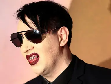 Rocker, Marilyn Manson berpose saat menghidiri di Fashion Awards 2016 di London, Inggris (5/12). Mengenakan Jas dan kacamata hitam Marilyn Manson tampil keren saat menghadiri acara tersebut. (REUTERS/Neil Balai)