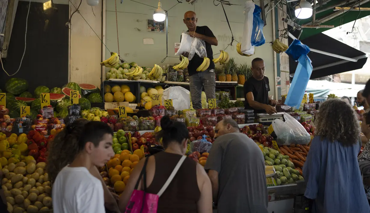 Orang-orang membeli buah dari pasar jalanan di Haifa, Israel, Jumat, 16 Agustus 2024.  (AP Photo/Leo Correa)