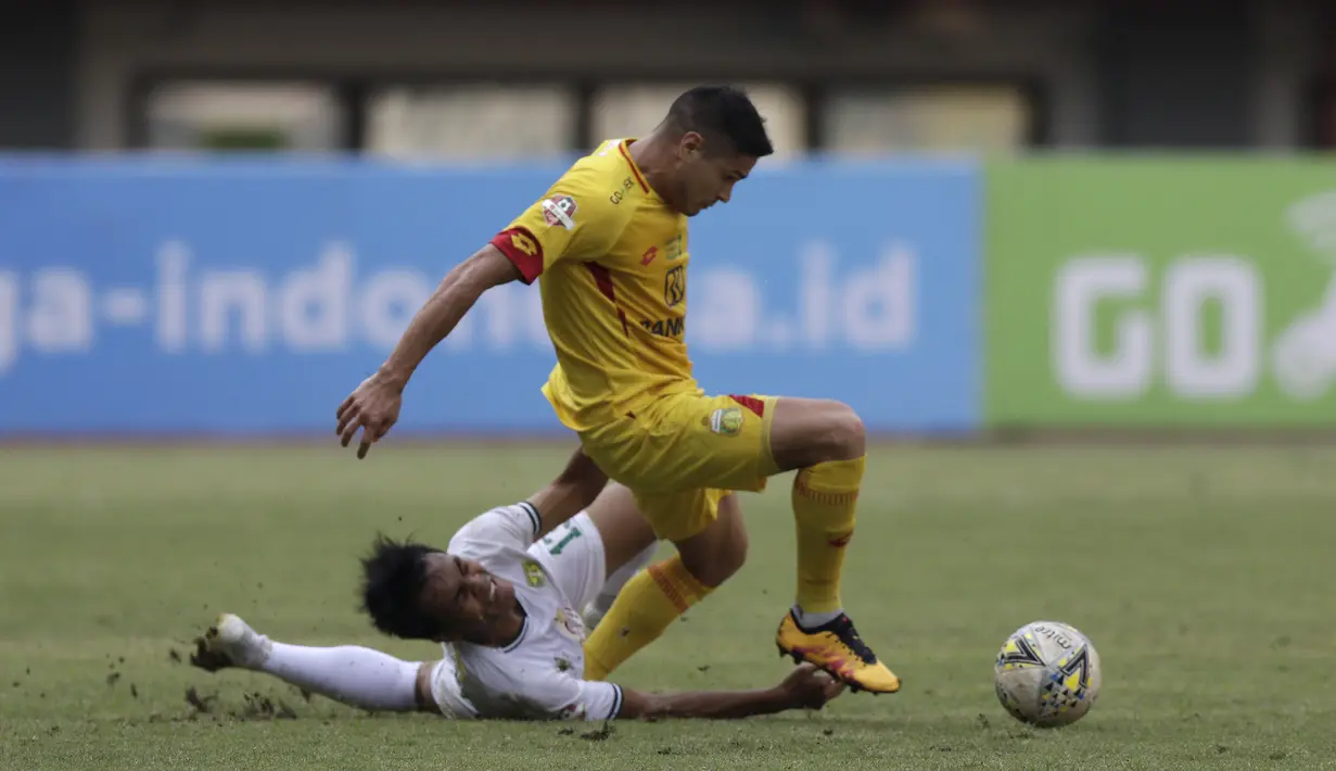 Striker Bhayangkara FC, Ramiro Ezequiel, berebut bola dengan pemain Persebaya pada laga Shopee Liga 1 di Stadion Patriot Chandrabhaga, Bekasi, Sabtu (31/8). Persebaya menang 2-0 atas Bhayangkara. (Bola.com/Yoppy Renato)