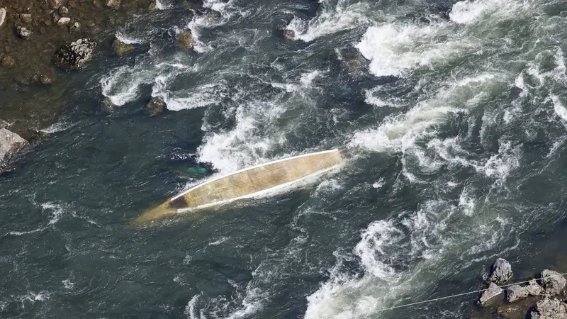Foto yang diambil dari helikopter Kyodo News memperlihatkan perahu wisata kayu tradisional yang terbalik di Sungai Hozu di Kameoka, Prefektur Kyoto, pada 28 Maret 2023.