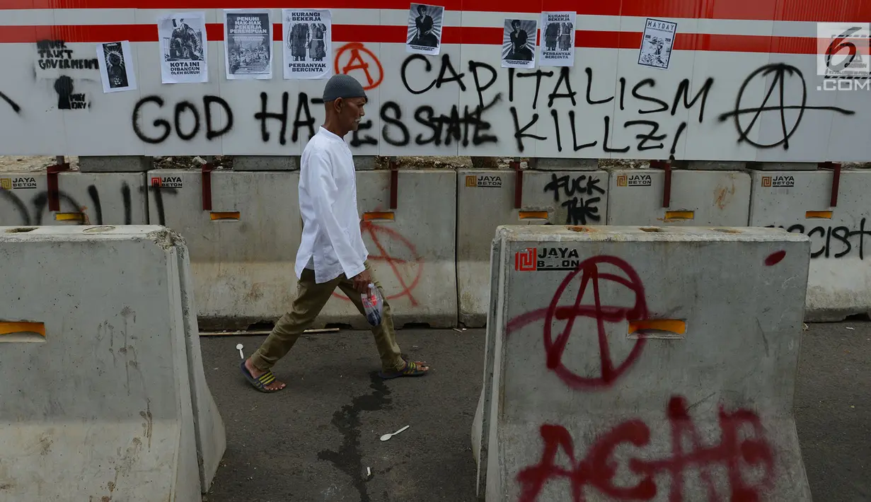 Pejalan kaki melintas dekat aksi vandalisme yang mewarnai Hari Buruh Internasional atau May Day di kawasan Bundaran HI, Jakarta, Rabu (1/5/2019). Belum diketahui siapa yang melakukan aksi corat coret di fasilitas publik tersebut. (merdeka.com/Imam Buhori)