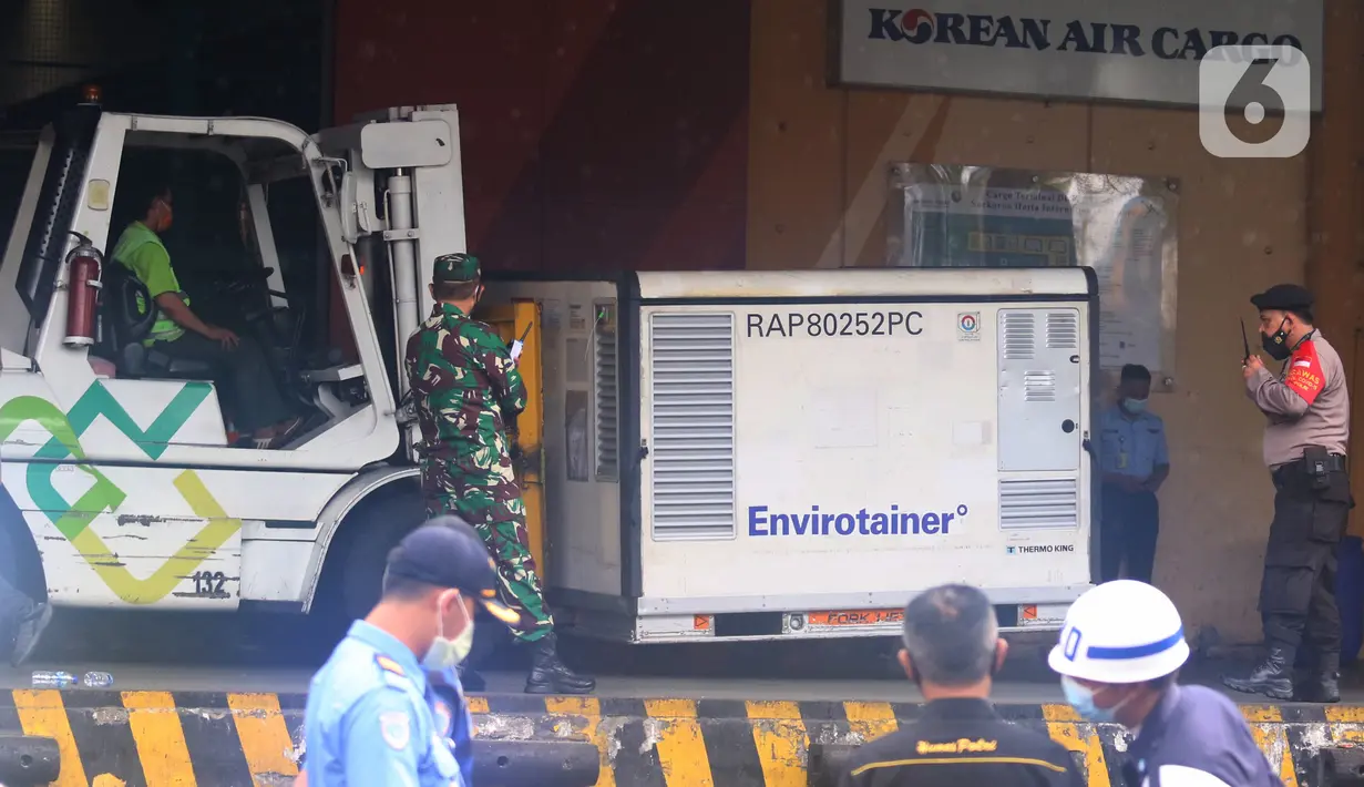 Pekerja memindahkan kontainer berisi vaksin COVID-19 saat tiba di Bandara Soekarno-Hatta, Tangerang, Kamis (31/12/2020). Setelah mendarat di Indonesia, 1,8 juta dosis vaksin Covid-19 produksi Sinovac akan langsung dikirim ke PT Bio Farma (Persero) di Bandung. (Liputan6.com/Angga Yuniar)
