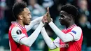 Striker Arsenal, Pierre-Emerick Aubameyang, merayakan gol yang dicetak Bukayo Saka ke gawang Eintracht Frankfurt pada laga Europa League di Frankfurt, Kamis (19/9). Frankfurt kalah 0-3 dari Arsenal. (AFP/Uwe Anspach)