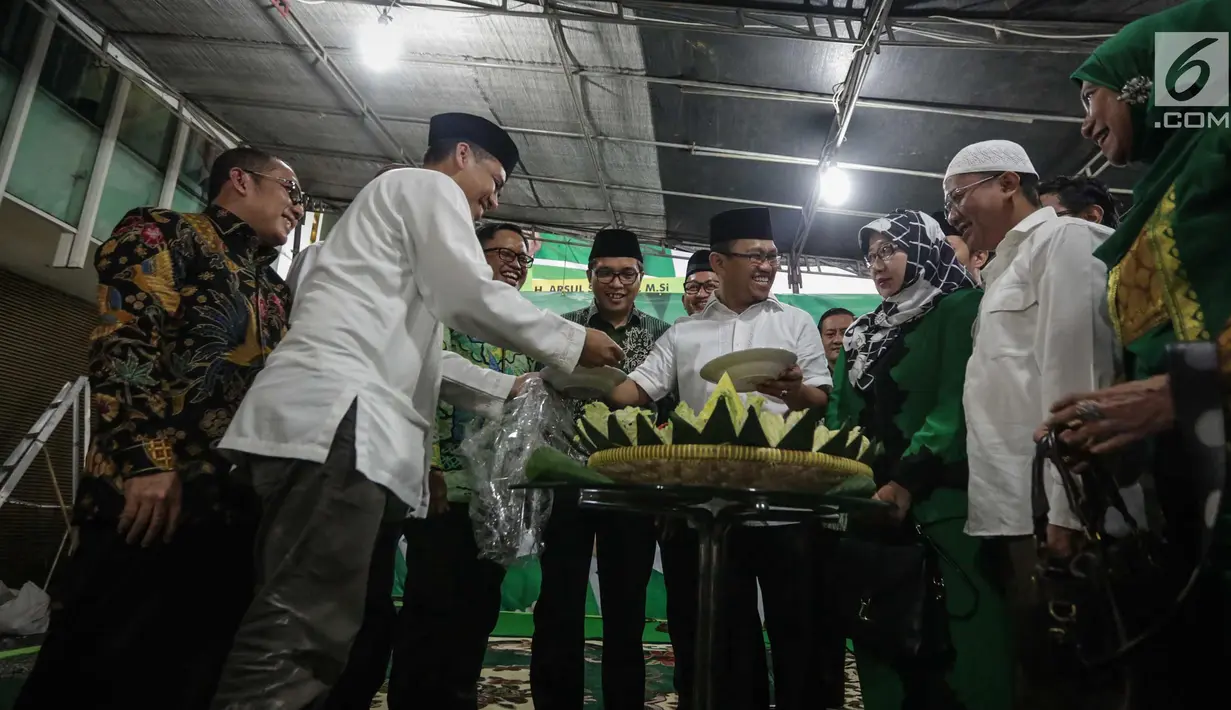 Wakil Ketua Umum (Waketum) DPP PPP Amir Uskara (tengah) memotong tumpeng selama acara Tasyakuran di Gedung DPP PPP, Diponegoro, Jakarta, Jumat (15/11). (Liputan6.com/Faizal Fanani)