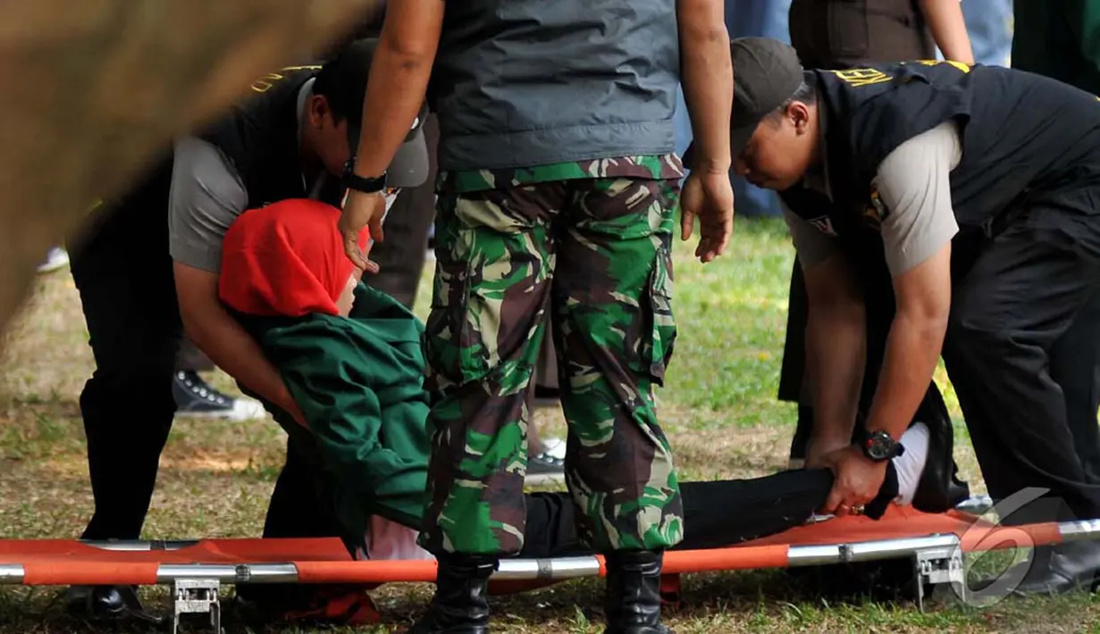 Diduga karena kelelahan mahasiswi ini terjatuh dari tempatnya berbaris. Iapun segera ditandu untuk mendapat perawatan, Jakarta, Rabu (1/10/2014) (Liputan6.com/Johan Tallo)