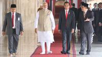 Presiden Joko Widodo dan PM India Narendra Modi berjalan di Masjid Istiqlal, Jakarta, Rabu (30/5). Kunjungan membahas kerja sama antara kedua negara serta untuk menyambut 70 tahun hubungan diplomatik Indonesia-India. (Liputan6.com/Angga Yuniar)