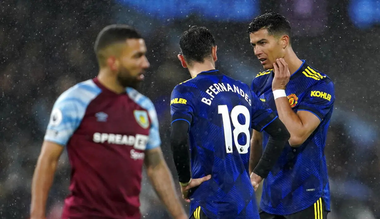 Pemain Manchester United Cristiano Ronaldo (kanan) berbicara dengan Bruno Fernandes saat melawan Burnley pada pertandingan sepak bola Liga Inggris antara Burnley dan Manchester United di Turf Moor, Burnley, Inggris, 8 Februari 2022. Pertandingan berakhir imbang 1-1. (AP Photo/Jon Super)