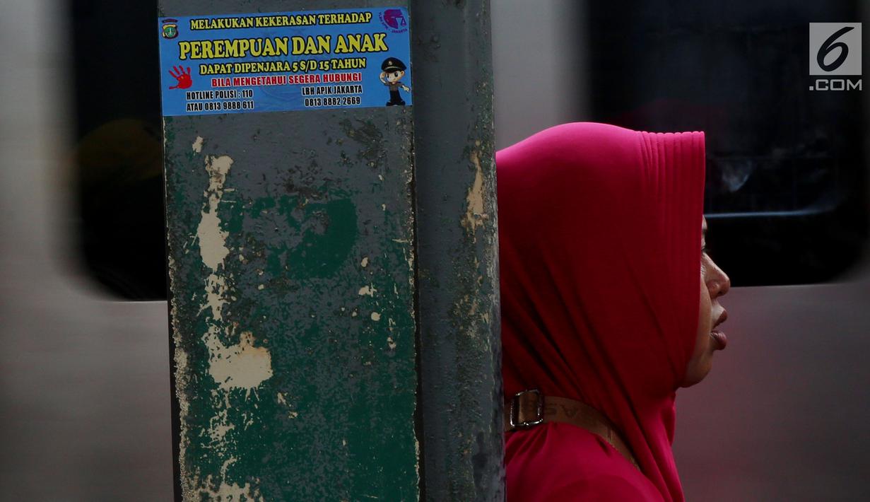 Stiker informasi pengaduan kekerasan ditempel di sekitar Stasiun Tanah Abang, Jakarta, Kamis (21/12). Stiker ini juga bertuliskan informasi tentang pengaduan ketika terjadi kekerasan pada wanita dan anak. (Liputan6.com/JohanTallo)