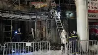 Petugas pemadam kebakaran memeriksa bangunan bar yang terbakar di Hanoi, Vietnam pada 19 Desember 2024 [Hau Dinh/AP]