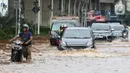 Pengendara terpaksa mendorong motornya saat melintasi genangan air di Jalan Boulevard Raya, Kelapa Gading, Jakarta, Rabu (29/1/2025). (Liputan6.com/Herman Zakharia)