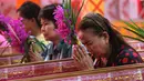 Sejumlah pemuja berdoa saat mereka duduk dalam peti mati di kuil Takien, pinggiran Bangkok, Thailand, Senin (31/12). Mereka mempercayai ritual ini dapat membantu menyingkirkan nasib buruk dan dianggap sebagai awal dari kehidupan baru. (AP/Sakchai lalit)