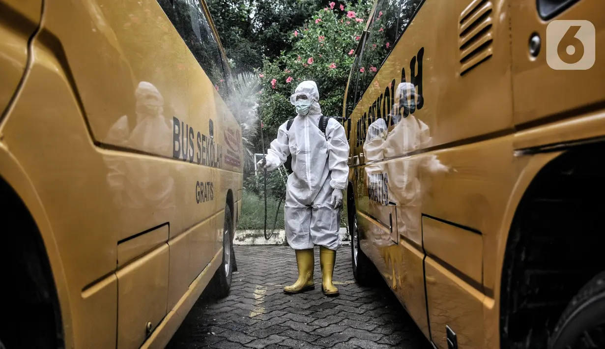 Petugas Kebersihan Bus (PKB) menyemprotkan disinfektan pada bus sekolah di Pool Unit Pelayanan Angkutan Sekolah (UPAS) DKI Jakarta, Kramat Jati, Selasa (5/1/2021). Sterilisasi bus sekolah rutin dilakukan usai digunakan mengangkut pasien terpapar Covid-19 ke RS rujukan. (merdeka.com/Iqbal Nugroho)