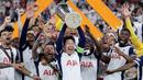 Son Heung-min (tengah) mengangkat trofi bersama para pemain Tottenham setelah menjuarai final Liga Europa 2024/2025 di Stadion San Mames, Bilbao, Spanyol, Kamis (22/05/2025) WIB. Tottenham menang dengan skor 1-0 atas Manchester United. (AFP/Thomas Coex)