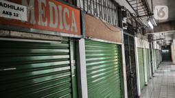 Deretan kios pedagang Pasar Pramuka saat ditutup sementara di Pasar Pramuka, Jakarta, Minggu (12/7/2020). Kegiatan jual beli di Pasar Pramuka ditiadakan selama tiga hari, mulai Sabtu (11/7) hingga Senin (13/7) setelah satu orang pedagang terkonfirmasi positif Covid-19. (merdeka.com/Iqbal Nugroho)