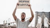 Ilustrasi HAM/ Hak Asasi Manusia (Photo by Lara Jameson: https://www.pexels.com/photo/man-in-a-gray-shirt-holding-a-human-rights-sign-8898590/)