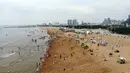 Foto yang diabadikan dari udara pada 9 Juli 2020 ini memperlihatkan orang-orang yang sedang menikmati waktu bersantai di sebuah pantai di Rizhao, Provinsi Shandong, China timur. (Xinhua/Wang Kai)