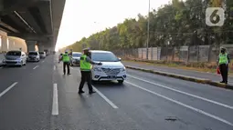 Polisi berjaga saat penyekatan di KM 31 Tol Jakarta-Cikampek, Kabupaten Bekasi, Jawa Barat, Sabtu (17/7/2021). Penyekatan ini juga untuk mendukung pemerintah dalam melaksanakan PPKM Darurat guna mencegah penyebaran COVID-19. (Liputan6.com/Herman Zakharia)