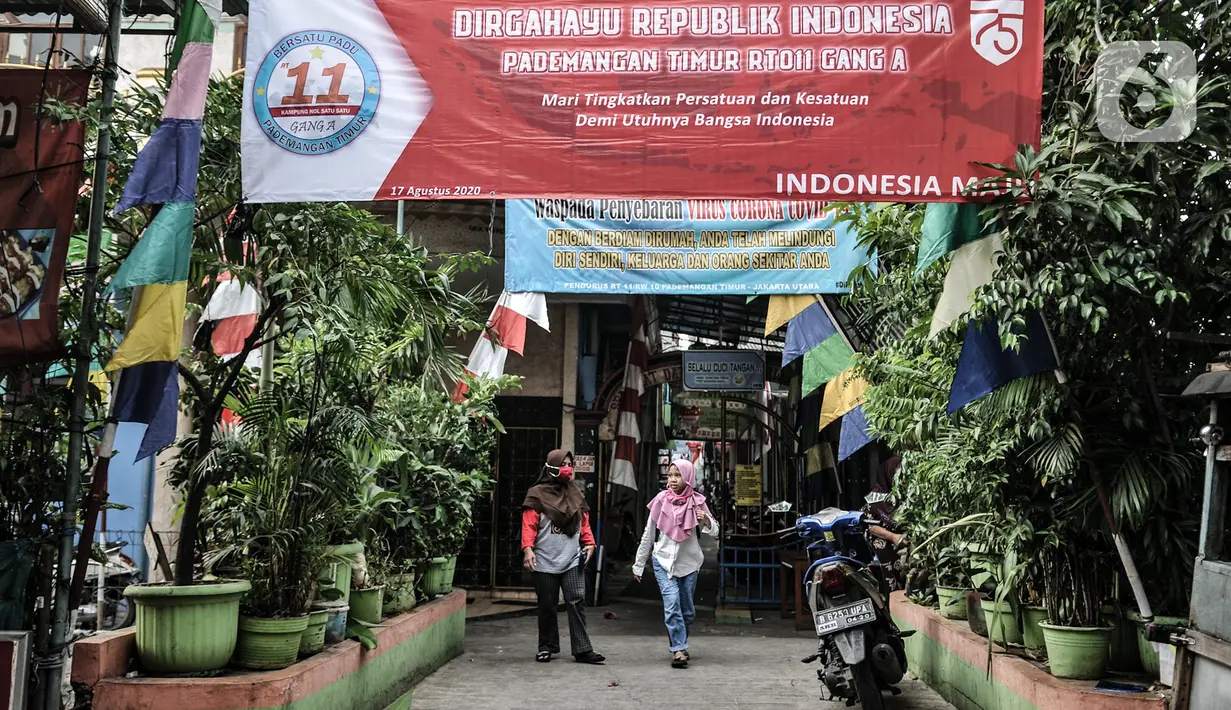 Warga melintas di depan Gang A, RT 10/11, Pademangan Timur, Jakarta, Rabu (5/8/2020). Tujuan menghias gang tersebut untuk memperindah lingkungan serta menyemarakkan perayaan HUT ke-75 RI. (merdeka.com/Iqbal S. Nugroho)