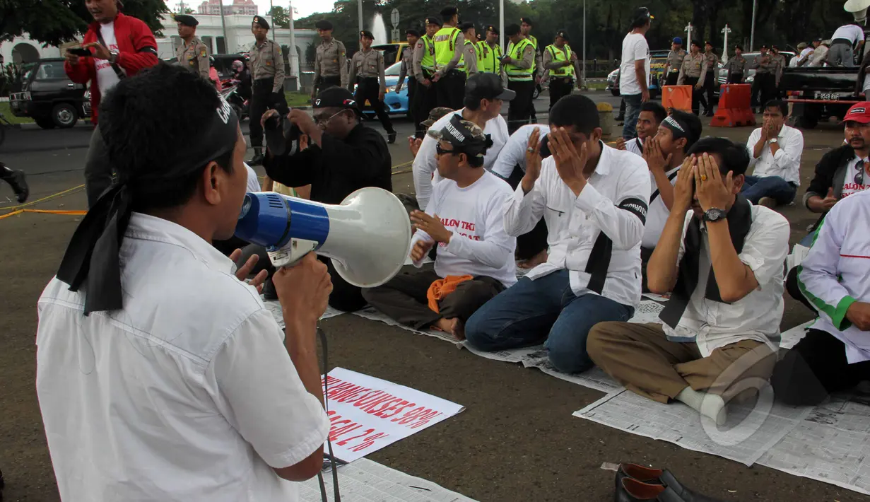 Massa dari Aliansi TKI Menggugat melakukan doa bersama saat aksi unjuk rasa di depan Istana Negara, Jakarta, Selasa (7/4/2015).  Mereka menuntut Presiden Jokowi mencabut moratorium larangan pengiriman TKI ke Timur Tengah. (Liputan6.com/Helmi Afandi)