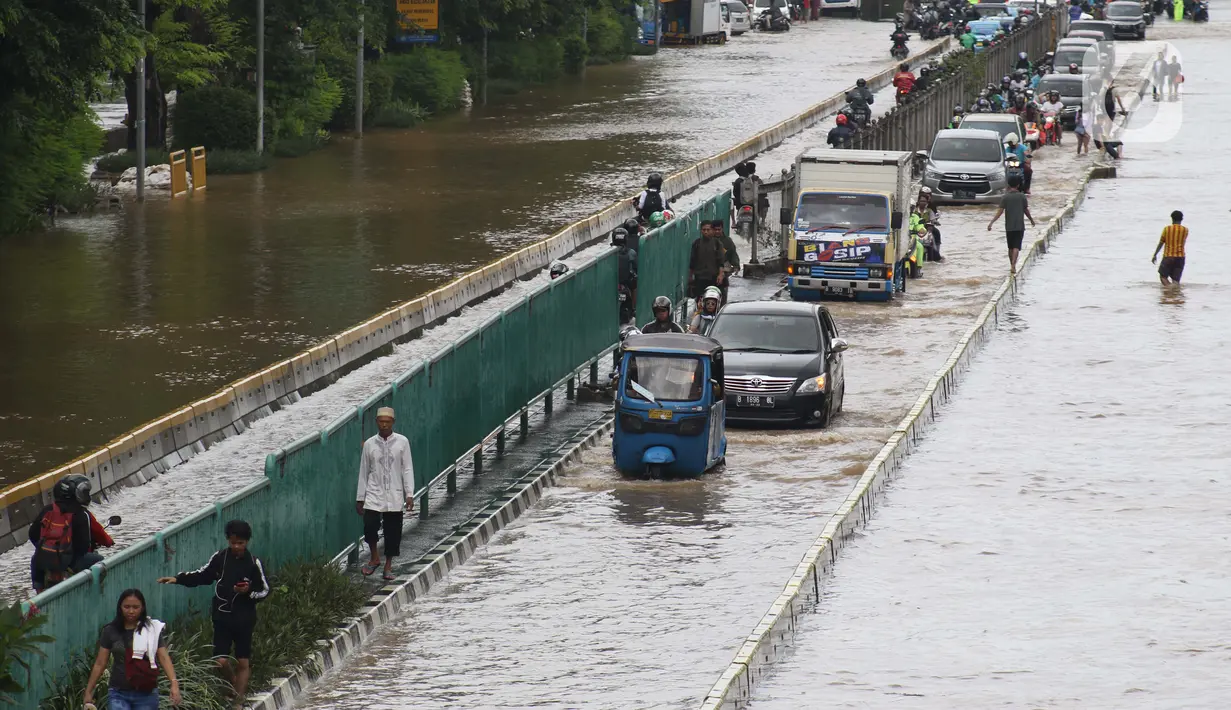 Sejumlah pengendara nekat menerobos genangan banjir di Jalan Gunung Sahari Jakarta, Selasa (25/2/2020). Hujan yang mengguyur Jakarta sejak Senin (24/2) malam membuat sejumlah kali meluap dan menyebabkan banjir. (Liputan6.com/Helmi Fithriansyah)