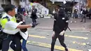 Polisi (kiri) menembak seorang demonstran prodemokrasi (kanan) saat terjadi protes di Distrik Sai Wan Ho, Hong Kong, Senin (11/11/2019). Aksi penembakan yang dilakukan polisi tersebut tersiar secara langsung lewat layanan streaming Facebook. (LAURENT FIEVET/CUPID NEWS/AFP)