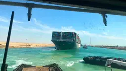 Kapal kargo Ever Given ditarik oleh salah satu kapal tunda di Terusan Suez, Mesir, Senin (29/3/2021). Kapal penarik membunyikan klakson mereka sebagai perayaan saat Ever Given sepanjang 400m (1.300 kaki) dicabut pada Senin 29 Maret dengan bantuan kapal keruk. (Suez Canal Authority via AP)