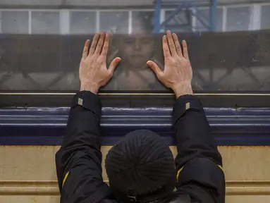Aleksander (41) menempelkan tangan ke jendela saat mengucapkan selamat tinggal kepada putrinya Anna (5) di kereta api ke Lviv di Stasiun Kiev, Ukraina, 4 Maret 2022. Aleksander tinggal untuk berperang, sementara keluarganya meninggalkan Ukraina untuk mencari perlindungan. (AP Photo/Emilio Morenatti)