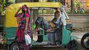 <p>Seorang pengemudi bajaj yang kelelahan karena panas yang hebat beristirahat di dalam kendaraannya ketika seorang perempuan yang menutupi wajah berjalan melewatinya, di New Delhi, India, Kamis (19/5/2022). Meskipun hujan sporadis, ibu kota India itu masih menghadapi kondisi panas yang ekstrem. (AP Photo/Manish Swarup)</p>