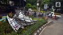 Kondisi lalu lintas saat petugas pemadam kebakaran memotong rangka reklame yang roboh di Jalan Soepomo, Jakarta, Sabtu (28/5/2022). Hujan disertai angin kencang pada pagi tadi membuat papan reklame roboh sehingga membuat kemacetan arus lalu lintas di jalan tersebut. (merdeka.com/Imam Buhori)