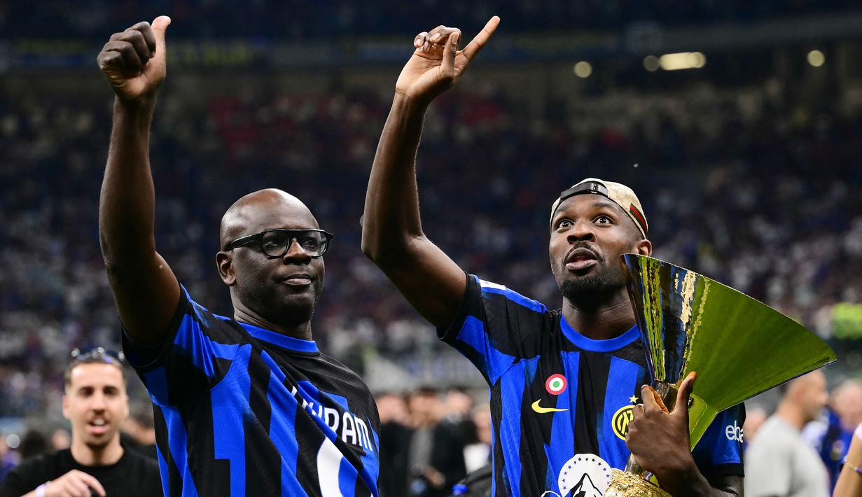 Pemain Inter Milan, Marcus Thuram, merayakan gelar juara Serie A bersama sang ayah yang juga seorang legenda Juventus yakni Lilian Thuram di Stadion Giuseppe Meazza, (19/5/2024). (AFP/Marco Bertorello)