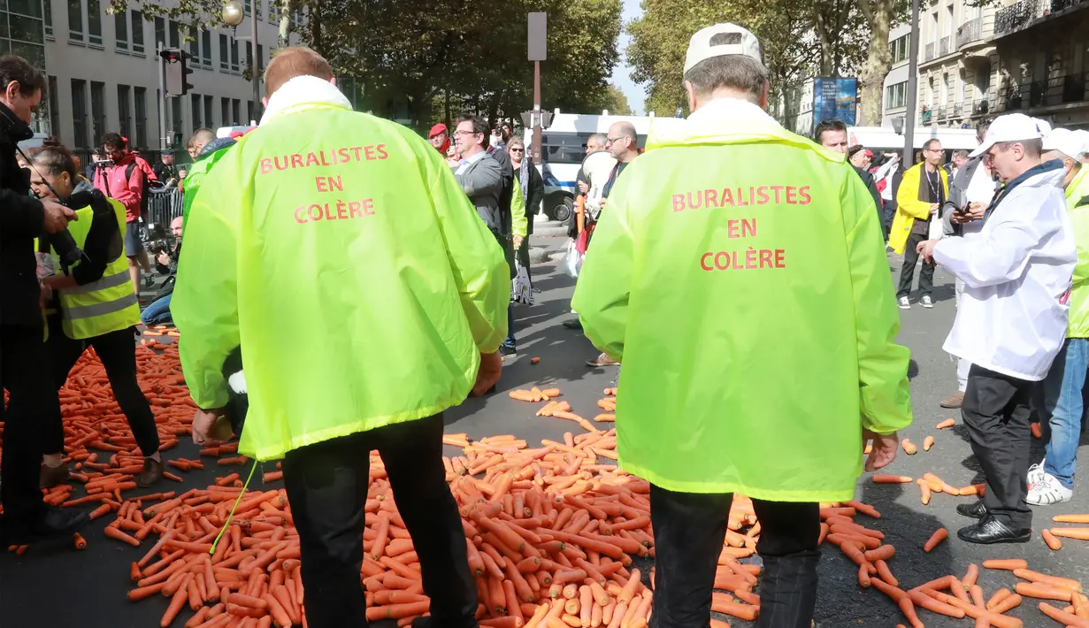 Demonstran membuang sebanyak 1,2 ton wortel ke jalanan depan kantor Kementerian Kesehatan di Paris, Rabu (4/10). Pemerintah ingin meningkatkan kesadaran masyarakat Paris agar berhenti merokok dengan cara menaikan harga rokok. (AFP PHOTO/JACQUES DEMARTHON)