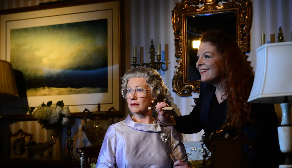 Seorang wanita memberikan sentuhan akhir pada patung lilin aktris Inggris Helen Mirren berpakaian sebagai Ratu Inggris Elizabeth II di museum lilin Madame Tussauds di Berlin pada 4 Februari 2013. (AFP/ JOHANNES EISELE)