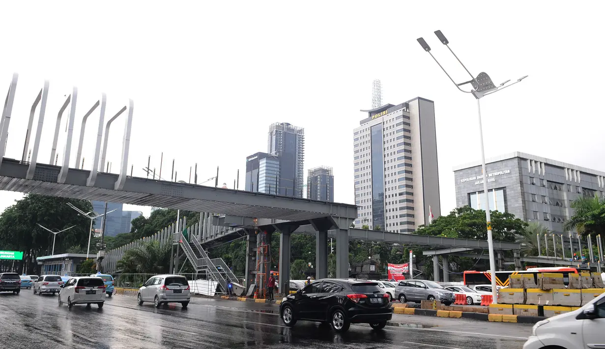 Kendaraan melintas jembatan penyeberangan orang (JPO) Polda Metro Jaya di kawasan Jenderal Sudirman, Jakarta, Sabtu (5/1). Revitalisasi tiga di kawasan Sudirman ditargetkan selesai pada pertengahan Januari 2019. (Liputan6.com/Herman Zakharia)