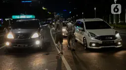 Manusia silver saat menghibur pengendara bermotor di perempatan kawasan Senayan, Jakarta, Sabtu (9/5/2020). Di tengah pandemi Covid-19 para manusia silver atau disebut "Patung Berjalan" itu tetap mengais rezeki untuk memenuhi kebutuhan sehari-hari (merdeka.com/Imam Buhori)