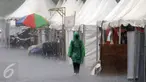 Seorang pengunjung melintas di depan stand produk pakaian pada Festival Kemang yang berlangsung di Jalan Kemang Raya, Jakarta (7/11/2015). Hujan deras disertai angin kencang mewarnai Festival Kemang hari pertama. (Liputan6.com/Helmi Fithriansyah)