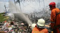 Petugas pemadam berusaha memadamkan api yang membakar ratusan rumah di Kampung Bandan, Ancol, Jakarta, Selasa (26/1). Kebakaran tersebut juga berdampak pada perjalanan KRL lintas Jakarta Kota-Manggarai. (Liputan6.com/Faizal Fanani)