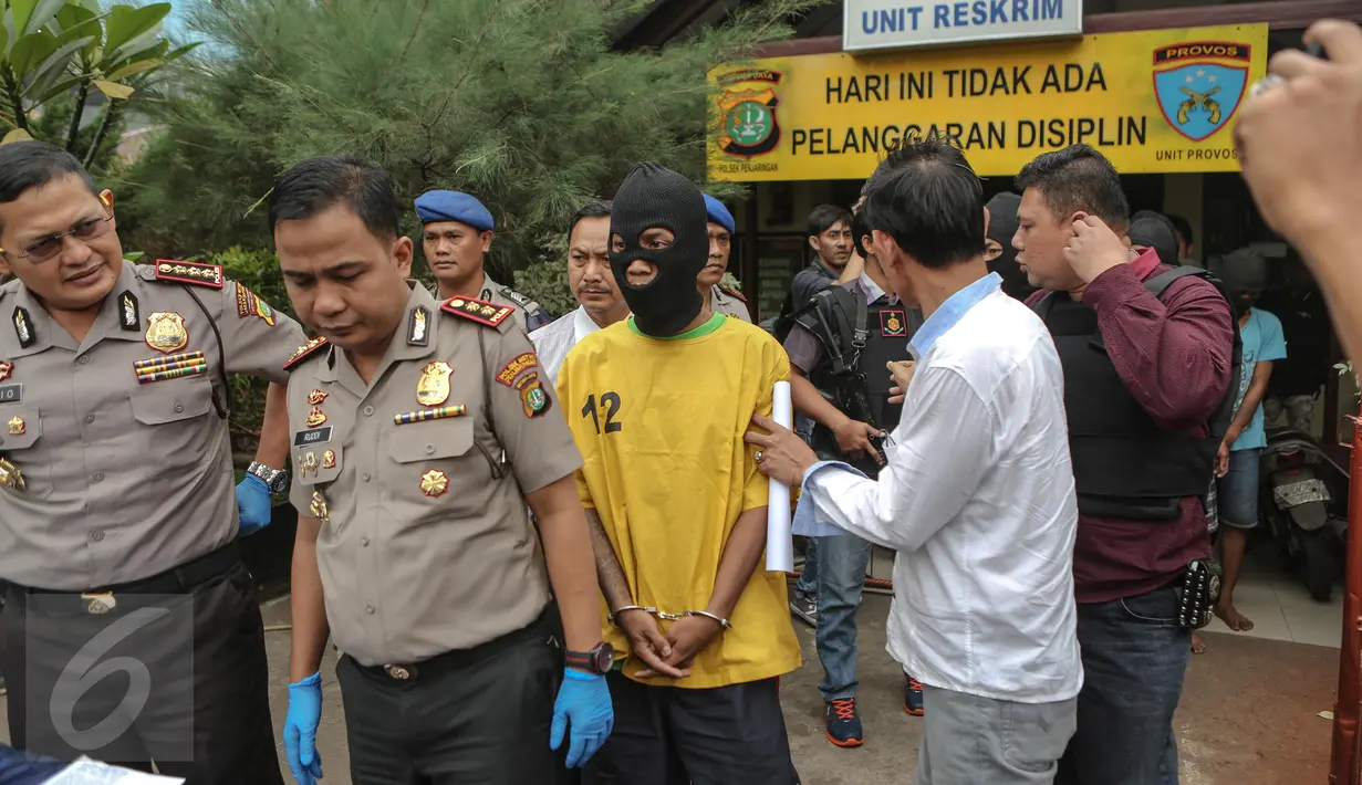 Petugas menghadirkan tersangka pelaku pembunuhan berencana yang terjadi di Kolong Tol Sedyatmo karena tidak terima pacarnya dilecehkan, di halaman markas Polsek Metro Penjaringan, Jakarta, Selasa (7/7/2015). (Liputan6.com/Faizal Fanani) 
