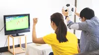 Ilustrasi menonton pertandingan sepak bola di rumah. (Shutterstock/Indypendenz)