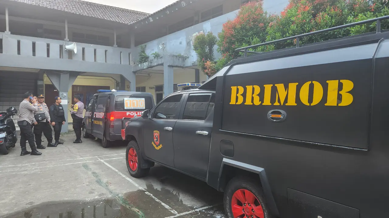 Anggota Brimob melakukan pengecekan terkait adanya teror bom di salah satu sekolah wilayah Depok (Liputan6.com/Dicky Agung Prihanto)